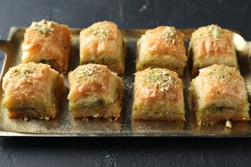 Delicious fresh baklava with chopped nuts on dark textured table, closeup. Eastern sweets
