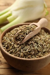 Bowl and scoop with fennel seeds on table, closeup