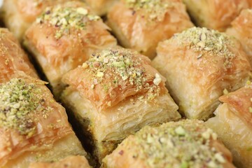 Delicious fresh baklava with chopped nuts as background, closeup. Eastern sweets