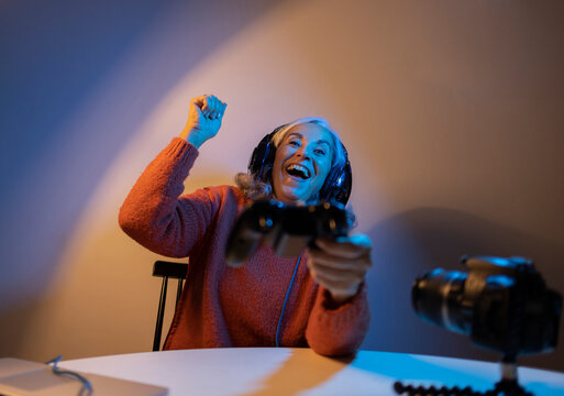 grandmother playing video games online and streaming live among neon lights
