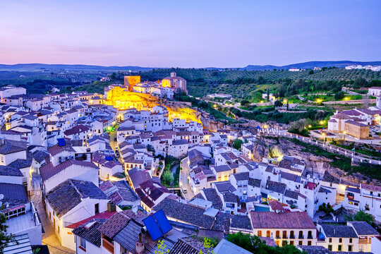 Setenil de las Bodegas with the medieval castle and the church at the hilltop, at dusk, Andalucia. Spain