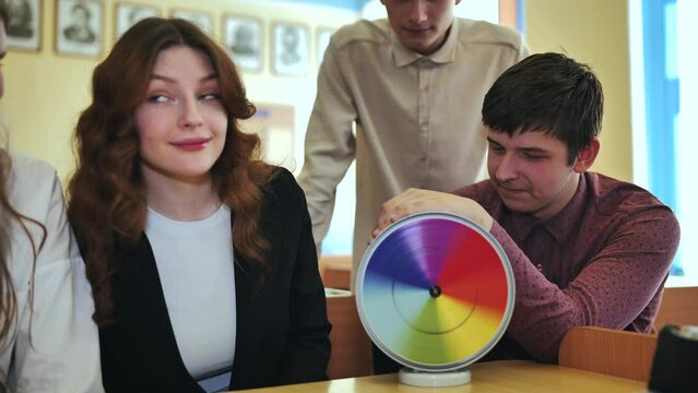 Students in physics class spin Newton's multicolored disk.