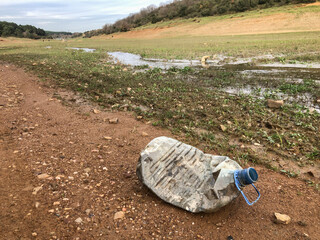 abandoned plastic bottle waste on land by dried lake