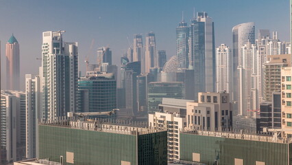 Dubai skyscrapers covered by morning fog in business bay district during sunrise timelapse.