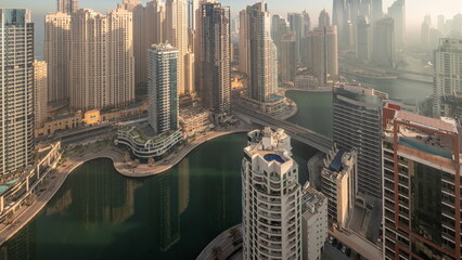 View of various skyscrapers in tallest recidential block in Dubai Marina aerial night to day...