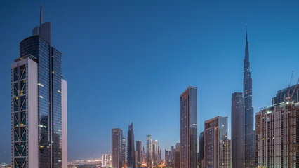 Foto op Canvas Aerial sunrise view of Dubai Downtown skyline with many towers night to day timelapse. © neiezhmakov
