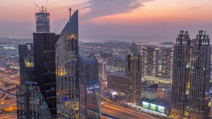 High-rise buildings on Sheikh Zayed Road in Dubai aerial day to night timelapse, UAE. - obrazy, fototapety, plakaty
