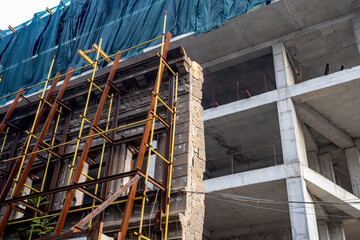 Building under construction. Erection residential complex. Process installing facade on monolithic building. Building business. Architectural industry. Construction residential skyscraper