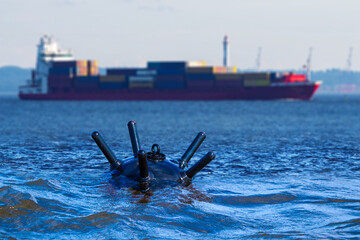 Underwater bomb near ship with containers. Ocean mine for organizing naval blockade. Underwater...