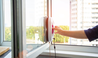 the girl attaches the vacuum window cleaner robot to the glass to clean it. State of the art window...