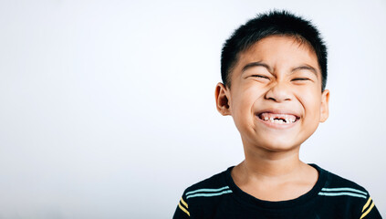 Schoolboy grins upper tooth lost gap shown in smile. Child dental care isolated on white. Joyful tooth fairy moment growth development. Children show teeth new gap, dentist problems