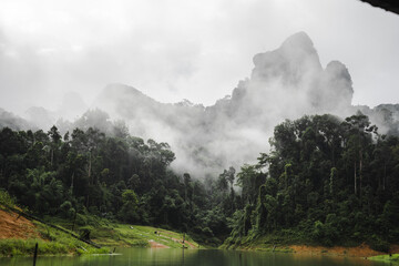 Mountains covered with fog near lake in Thailand