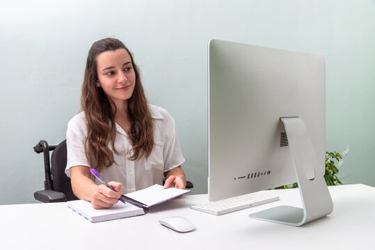 Professional woman in wheelchair working at a modern desk setup