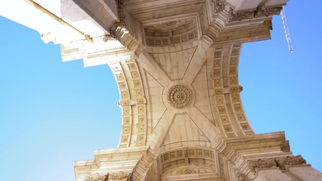 Famous Augusta arch - Arco da Rua Augusta, situated Commerce Square - Pra&ccedil;a do Com&eacute;rcio - Downtown Lisbon. Portugal. Camera spinning under the arch. Beautiful architecture details. Blue sky. 