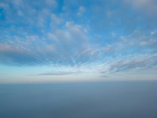 This photograph, taken with a drone above the mist, presents a breathtaking view akin to being above cloud level. The mist blankets the landscape, creating a seamless horizon where sky merges with the