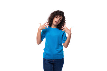 a young woman with a curly hairstyle above her shoulders in blue comfortable clothes feels confident