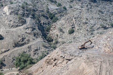Heavy machinery in the process of mountain road construction works in Saudi Arabia