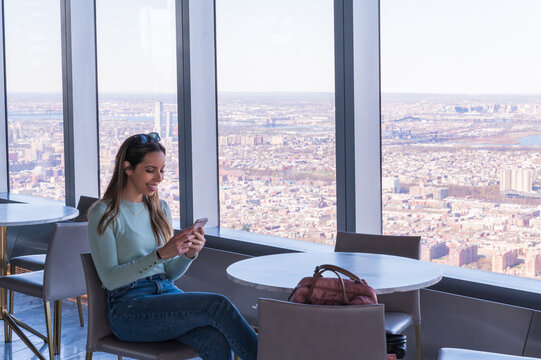 Woman at cafe with expansive Manhattan backdrop