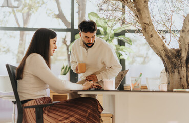 Obraz premium Diverse colleagues collaborating in office, discussing project details and sharing ideas for business success.