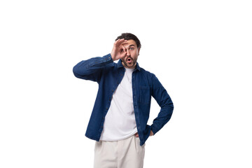 young handsome brunet european guy in a denim shirt over a white t-shirt on a white background
