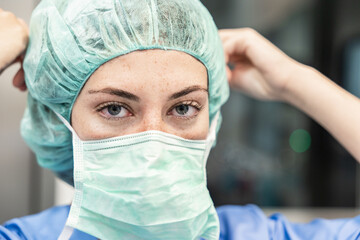 Female surgeon in hospital with medical mask and cap