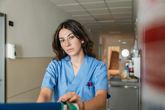 Professional female doctor sitting at hospital corridor in clinic
