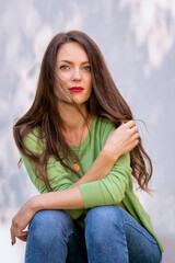 Portrait of beautiful young woman with green eyes and brunette haired against white background