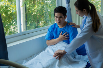 An Asian male patient lies in a hospital bed and is carefully looked after by a doctor. Doctor giving advice to male patient Working on health disease diagnosis