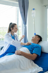 An Asian male patient lies in a hospital bed and is carefully looked after by a doctor. Doctor giving advice to male patient Working on health disease diagnosis