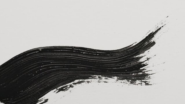 Black mascara stroke. Macro shot a of a black mascara isolated on white background. Professional makeup.