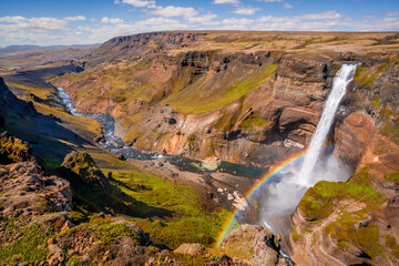 Háifoss waterfall with rainbow and valley on a sunny day