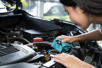 A woman is checking the engine coolant level. - obrazy, fototapety, plakaty