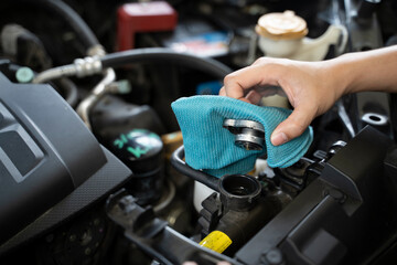A woman is checking the engine coolant level.