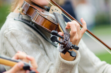 hands of a street musician girl with violin close up