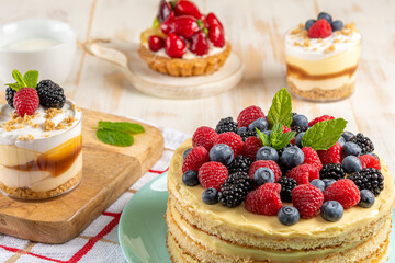 Homemade cake with fresh berries on wooden background.
