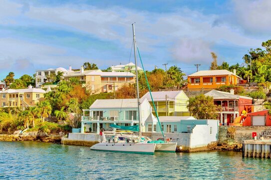 Catamaran in The Great Sound, moored in front of typical pastel coloured properties, Bermuda, Atlantic