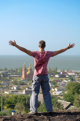 young athletic man spread his arms over the cliff