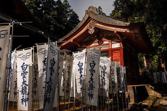 White banners with kanji written on it at The Mount Iwaki Shrine, near Hirosaki, North Honshu, Japan
