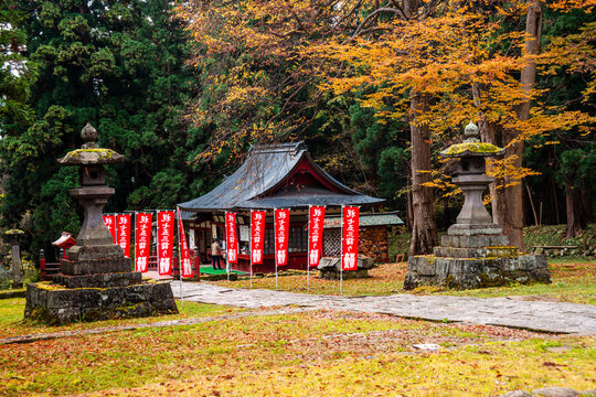 View of a Japanese temple, stone lanterns in an autumnal forest, The Mount Iwaki Shrine, near Hirosaki, North Honshu, Japan