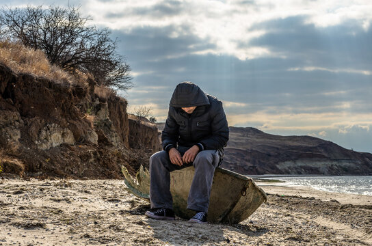 man is sitting aboard a broken boat