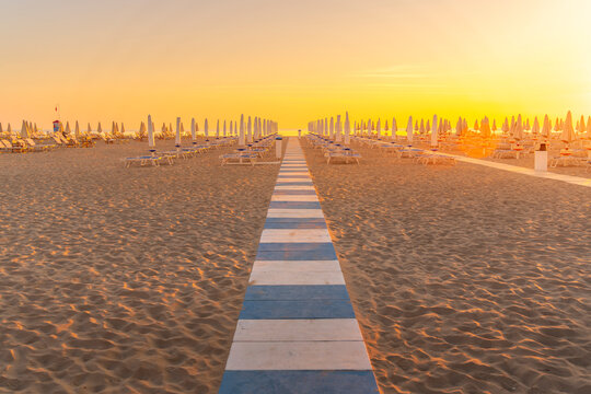 View of sunrise and sunshades on the Lido on Rimini Beach, Rimini, Emilia-Romagna