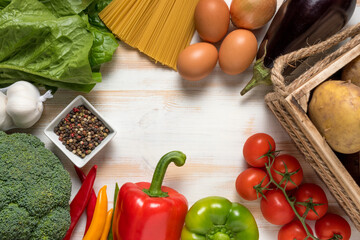 Colorful vegetables and spaghetti on wooden background with copy space.