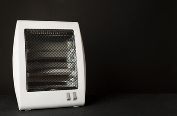 Portable electric halogen heater on black background