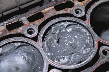 Close-up of a damaged piston of an internal combustion engine with carbon deposits in the cylinder...