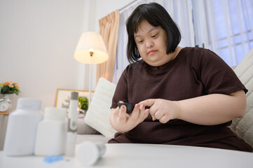 Asian fat woman A diabetic patient is watching blood results on a blood sugar meter with a blood...