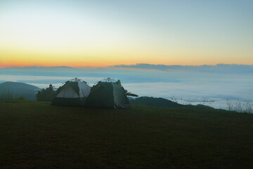 two tents for camping on top of mountain with sea of mist in the morning.