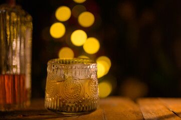 Whiskey glass with ice on a wooden table Beautiful night whiskey with alcohol copy concept on colorful bokeh night background