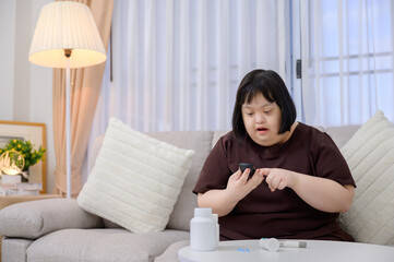 Asian fat woman A diabetic patient is watching blood results on a blood sugar meter with a blood...