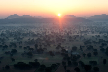 Sun rising over the hills and countryside surrounding Samode, from hot air balloon, Rajasthan, India