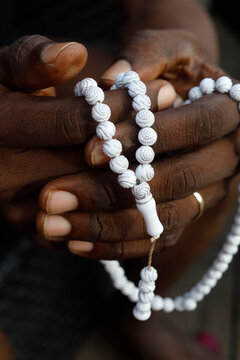 Close-up of hands of African Muslim man praying with Islamic prayer beads (tasbih), Togo, West Africa